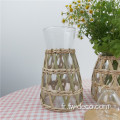 Vase de fleurs de la pot à verre enveloppé d'herbe naturelle